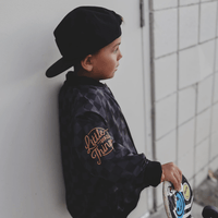 Kids waterproof letterman jacket by Little Rad Things with checkered pattern, featuring a warm, durable outer layer.
