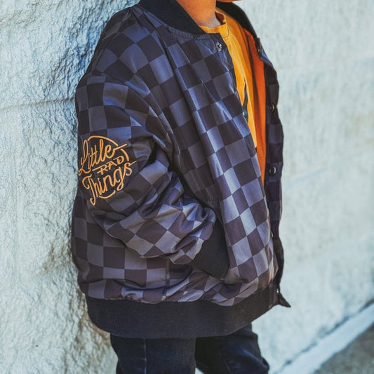 Kids waterproof letterman jacket by Little Rad Things with checkered pattern, featuring a stylish and durable design for children.