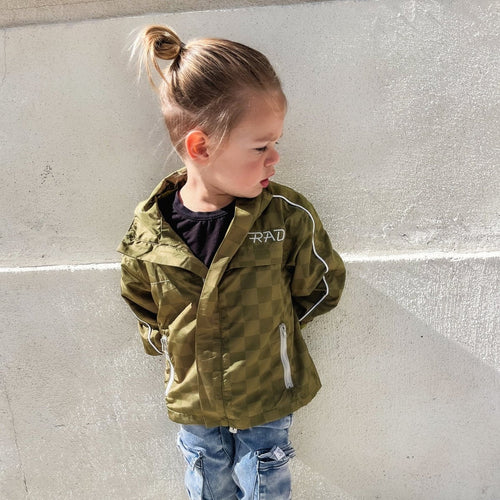 Little Rad Things Storm Rider waterproof jacket in army green displayed on a hanger, showcasing its durable outdoor design.