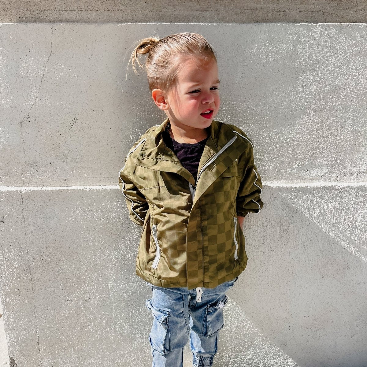Little Rad Things Storm Rider waterproof jacket in army green, showing the durable, waterproof fabric and adjustable hood.