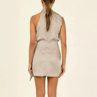 Mandotos elegant halter neck sleeveless short dress with waist tie, perfect for evening parties, worn by a woman.