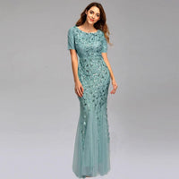 Elegant black evening dress by MANDOTOS, featuring a floor-length gown with a fitted bodice and flowing skirt.