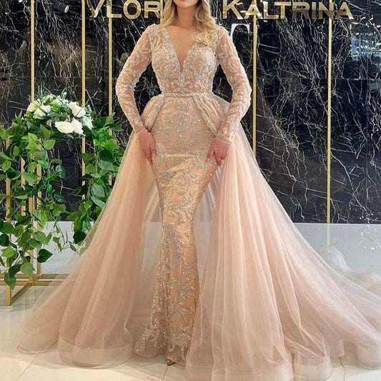 Simple French style long-sleeved wedding dress by MANDOTOS with elegant design and flowing fabric, shown on a model.