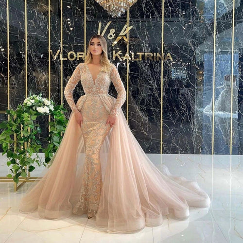 Elegant French style wedding dress by MANDOTOS with long sleeves and simple, flowing design, shown on a model.