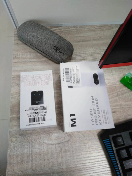 Mandotos LEING FST virtual laser Bluetooth wireless keyboard projecting onto a surface, with integrated mouse function for computer and phone use.