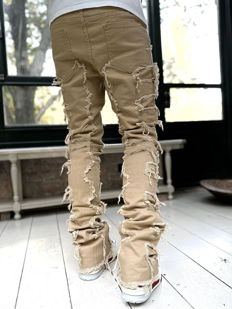 Mandotos men's stacked jeans with patched design, long tight fit trousers showcasing bold style and rugged denim details.