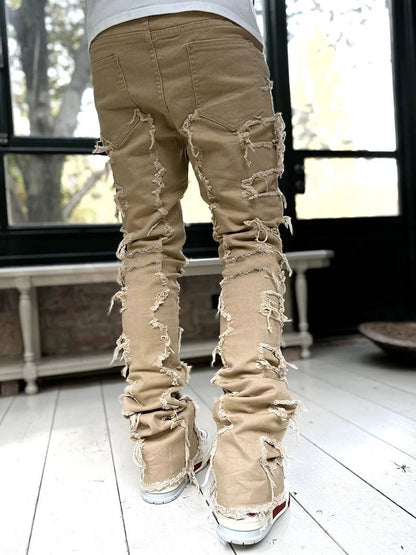 Mandotos men's stacked jeans with patched design, long tight fit trousers showcasing bold style and rugged denim details.