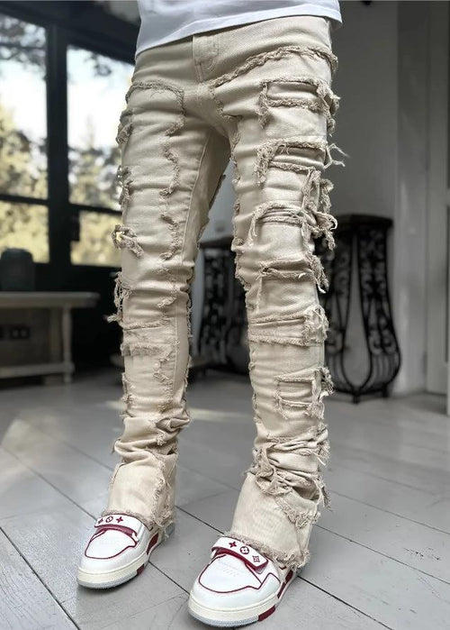 Men's stacked jeans by MANDOTOS featuring patched details, long tight fit trousers with bold style and modern denim design.