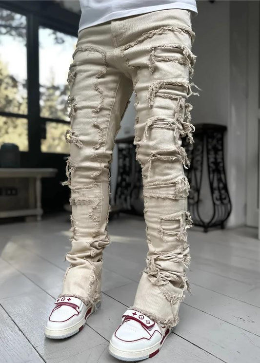 Men's stacked jeans by MANDOTOS featuring patched details, long tight fit trousers with bold style and modern denim design.