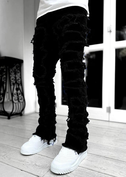 Men's stacked jeans by Mandotos featuring patched design and long tight fit for a bold, stylish look.