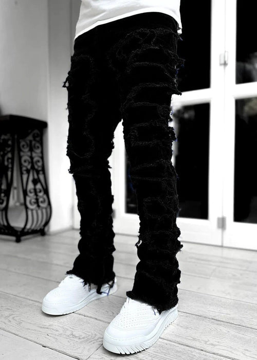 Men's stacked jeans by Mandotos featuring patched design and long tight fit for a bold, stylish look.