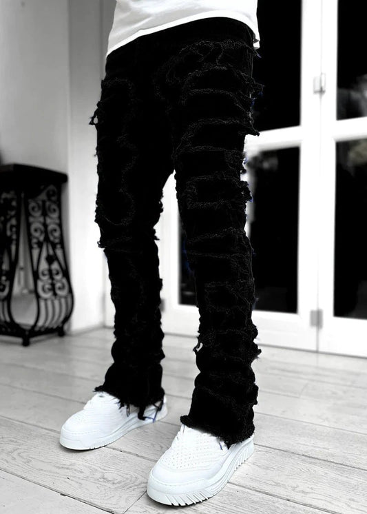 Men's stacked jeans by Mandotos featuring patched design and long tight fit for a bold, stylish look.