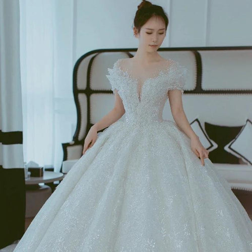 Off shoulder French main wedding dress by MANDOTOS featuring elegant lace details and a flowing silhouette.