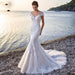 Mandotos Princess Bride Mermaid wedding dress in white with lace details, trailing backless design, elegant bridal gown.