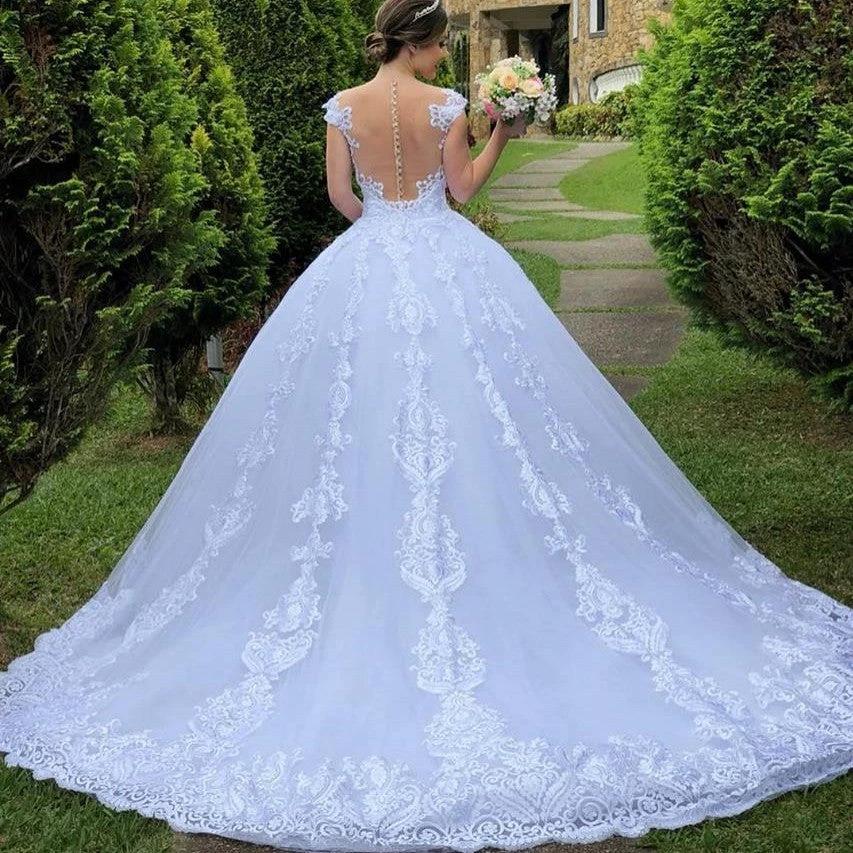 White vintage lace wedding dress by MANDOTOS featuring elegant lace details and a classic bridal gown silhouette.