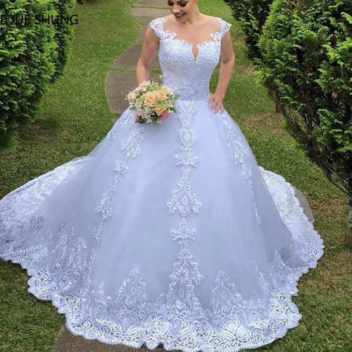 White vintage lace wedding dress by MANDOTOS featuring elegant lace details and a classic bridal gown silhouette.