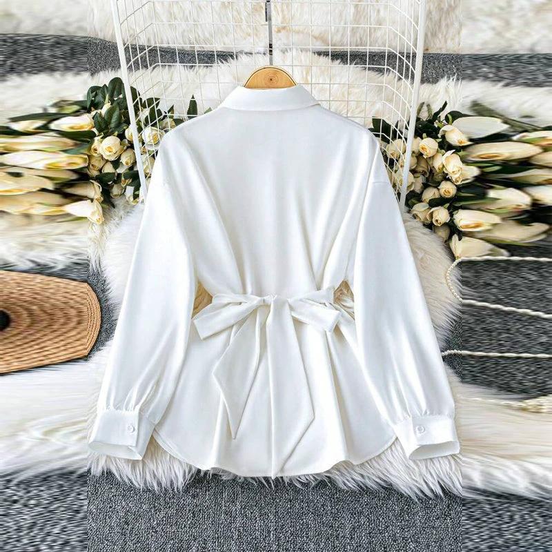 Women's solid color blouse with lapel collar, button-down front, adjustable metal waist belt, loose fit, suitable for casual or office wear.