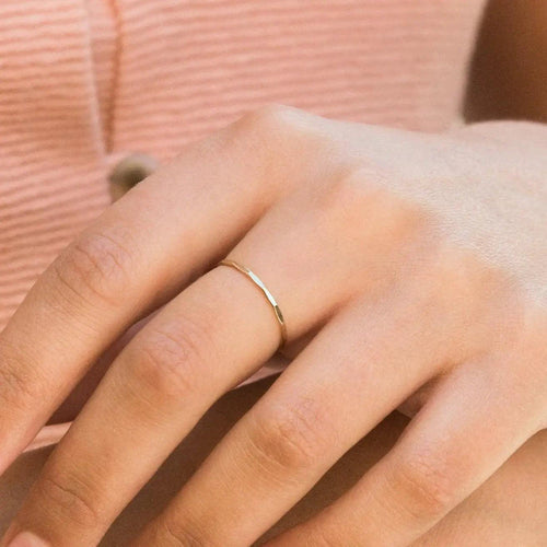 14K gold-filled textured stacking ring from MANDOTOS, featuring a shiny, hammered finish on a sleek band.
