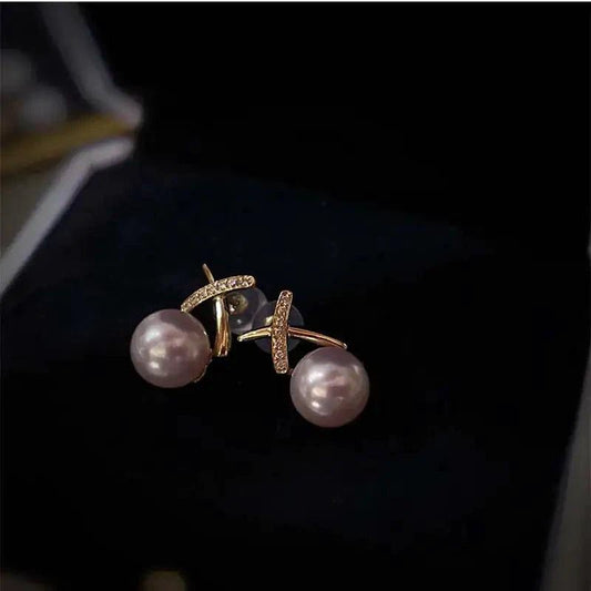 18K gold pearl stud earrings by MANDOTOS featuring elegant round white pearls and a classic, sophisticated design.