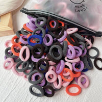 Assorted colorful elastic hair bands and scrunchies for kids, including hair ties and clips, ideal for children's hair accessories.