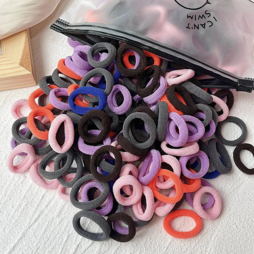 Assorted colorful elastic hair bands and scrunchies for kids, including hair ties and clips, ideal for children's hair accessories.