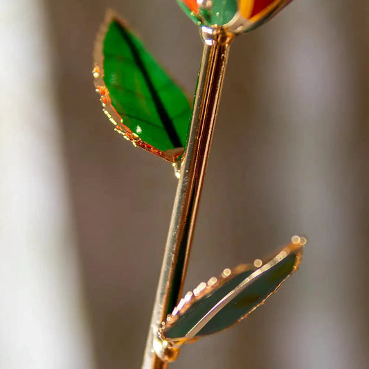 24K gold-plated rose gift by MANDOTOS, showcasing a beautifully crafted golden rose on a clear display stand