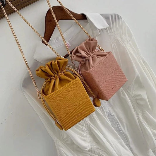 Mandotos chic alligator pattern bucket bag with rounded top handle and gold-tone hardware, stylish and trendy accessory.
