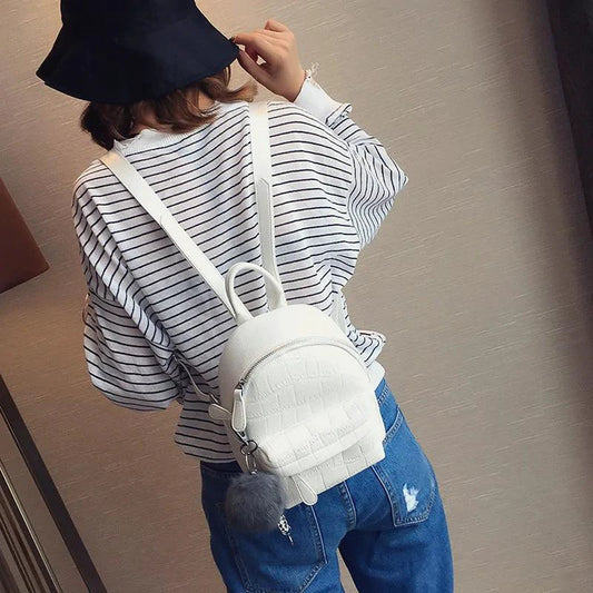 Mandotos chic mini leather backpack showing a compact black leather bag with a top handle and adjustable shoulder straps.