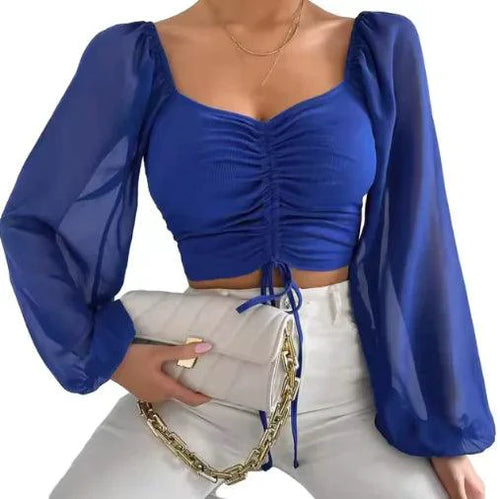 Mandotos chic V-neck crop top with balloon sleeves, stylish and trendy, shown in a close-up of the black fabric and design details.