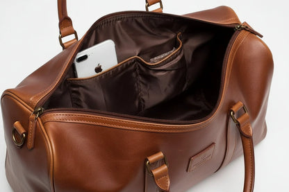 Mandotos classic leather duffel bag with sturdy handles and spacious interior, ideal for travel and weekend trips.