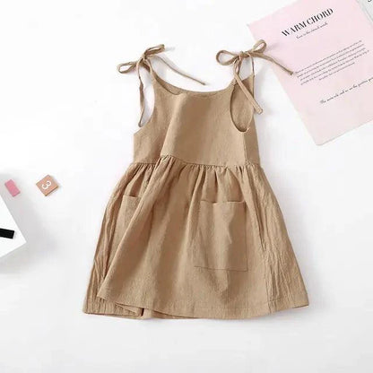 Toddler girl wearing a white cotton chic sundress by MANDOTOS, featuring a sleeveless design and floral pattern.