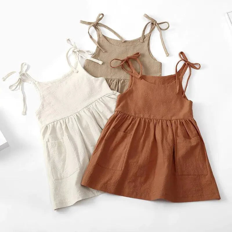 Toddler girl wearing a white cotton chic sundress by MANDOTOS, featuring a sleeveless design and floral accents.
