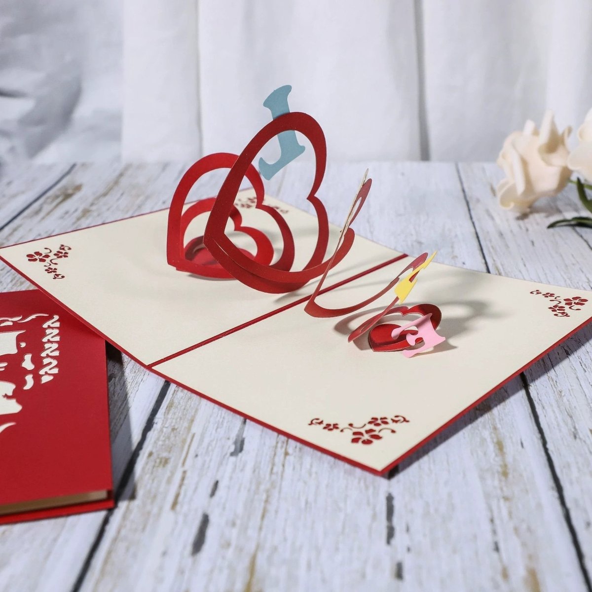 Mandotos 3D laser-cut engagement card with red heart and romantic silhouette design.