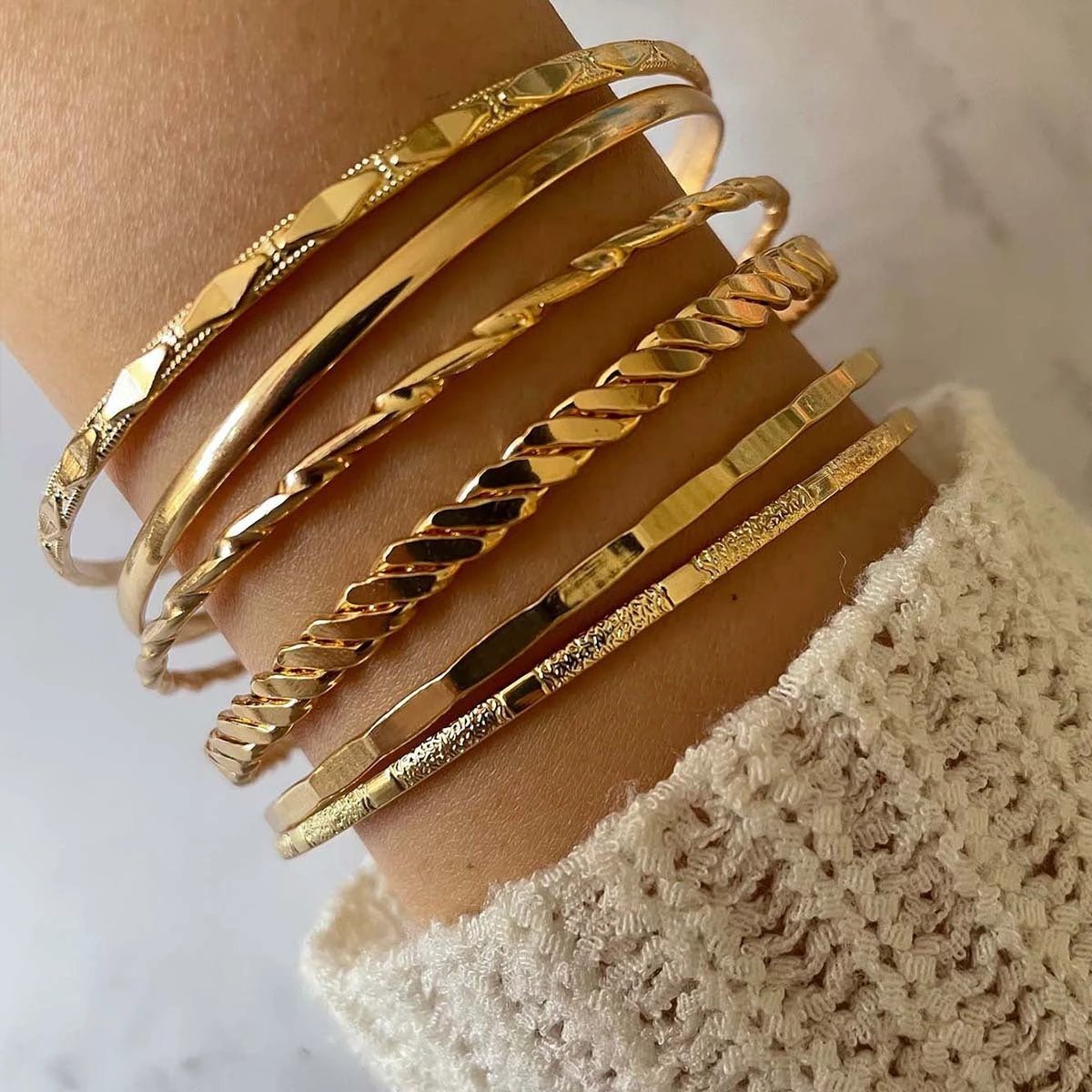 Mandotos Bohemian metal chain bracelet set for women with six gold-colored geometric thick link bangles on a white background.