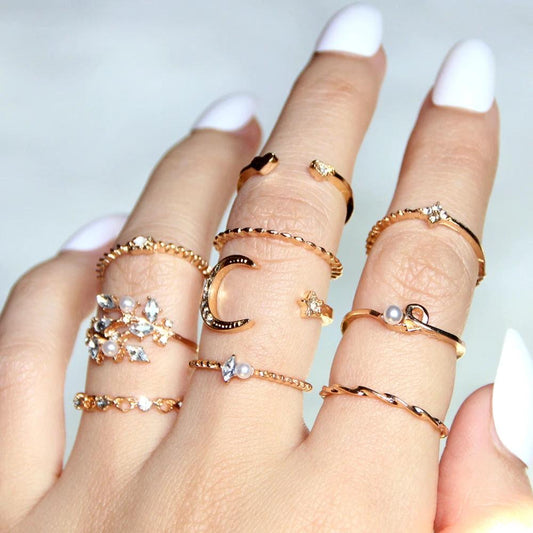 Mandotos Bohemian star, moon, pearl, and leaf 10-piece ring set with gold finish and stackable designs.