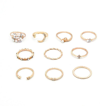 Mandotos bohemian star, moon, pearl, and leaf 10-piece gold finish ring set with stackable designs on a white background.