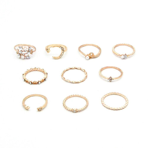 Mandotos bohemian star, moon, pearl, and leaf 10-piece gold finish ring set with stackable designs on a white background.
