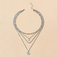 Mandotos chunky gold layered necklace featuring a coin pendant and sun charm for women, stylish jewelry accessory.