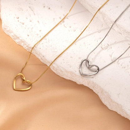 Stainless steel twist hollow heart necklace by MANDOTOS, featuring a delicate clavicle chain with a hollow heart pendant.