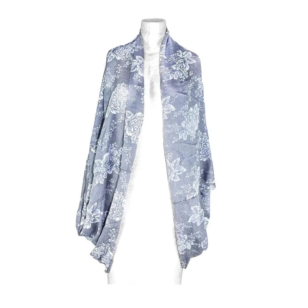 Mandotos denim blossom poncho featuring floral embroidery and lightweight denim fabric, styled with a relaxed fit and fringed edges.