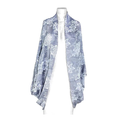 Mandotos denim blossom poncho featuring floral embroidery and lightweight denim fabric, styled with a relaxed fit and fringed edges.