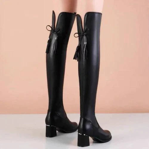 Black elastic leather knee boots by MANDOTOS with sleek design and sturdy heel, ideal for stylish fall or winter wear.