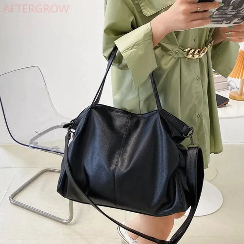 Elegant leather carryall bag by MANDOTOS with sturdy handles and sleek design, perfect for stylish everyday use.
