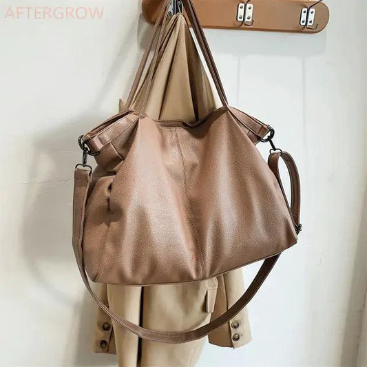 Elegant leather carryall bag by MANDOTOS with sturdy handles and sleek design, perfect for stylish everyday use.