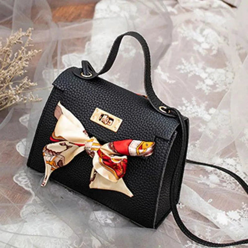 Elegant leather handbag paired with a matching scarf from MANDOTOS, displayed with the accessories on a neutral background.