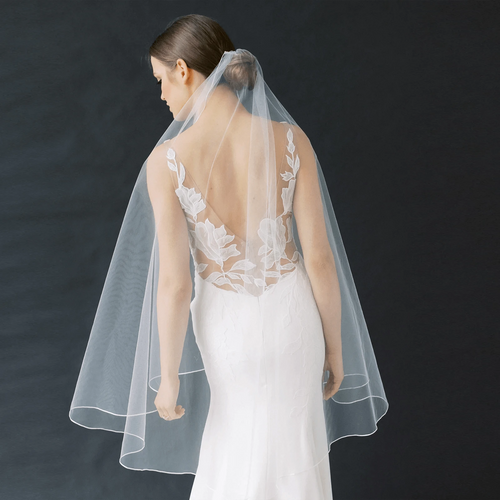 Long, flowing bridal veil by MANDOTOS with elegant lace trim, perfect for wedding ceremonies and formal bridal attire.