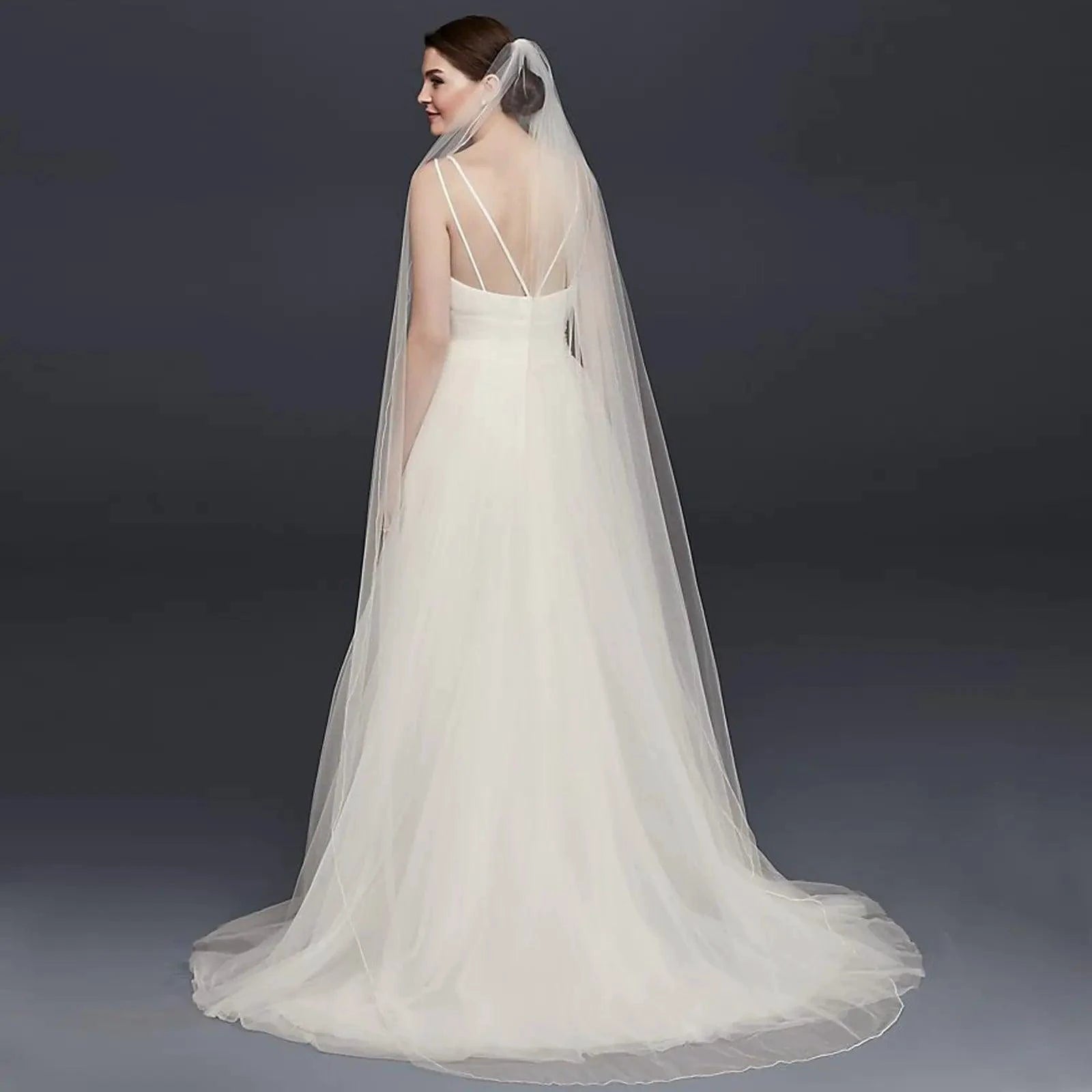 Long flowing wedding veil by MANDOTOS, ElegantBride V14 with delicate lace edging and soft tulle fabric for bridal elegance.