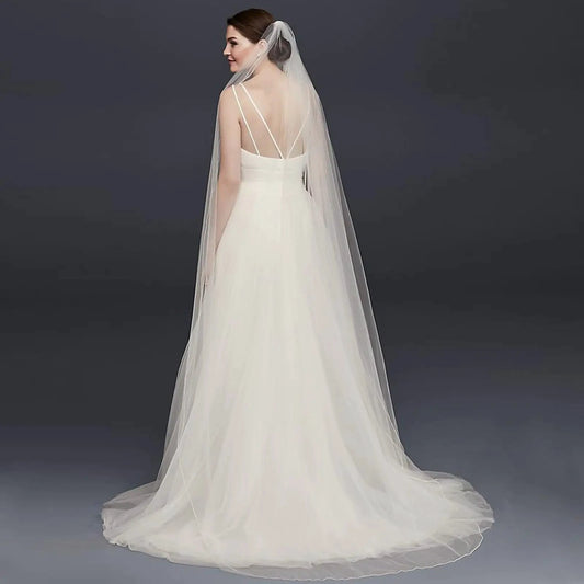 Long flowing wedding veil by MANDOTOS, ElegantBride V14 with delicate lace edging and soft tulle fabric for bridal elegance.