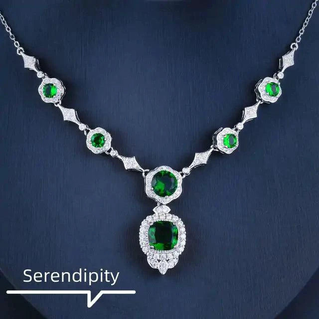 Mandotos Emerald Elegance white gold necklace featuring a central emerald gemstone and delicate chain design.