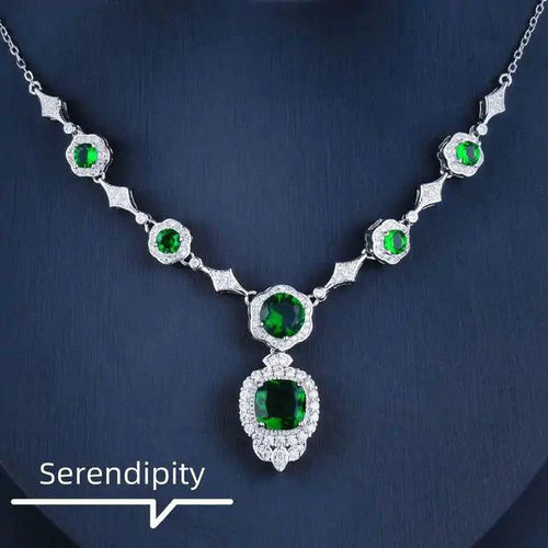 Mandotos Emerald Elegance white gold necklace featuring a central emerald gemstone and delicate chain design.